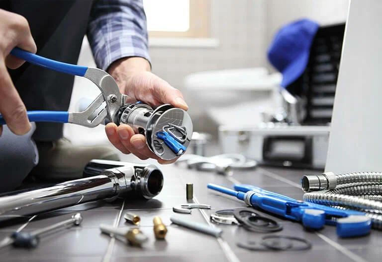 Technician repairing a plumbing fixture with professional tools in Lakeland