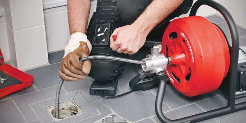Plumber using a drain-cleaning machine in Lakeland